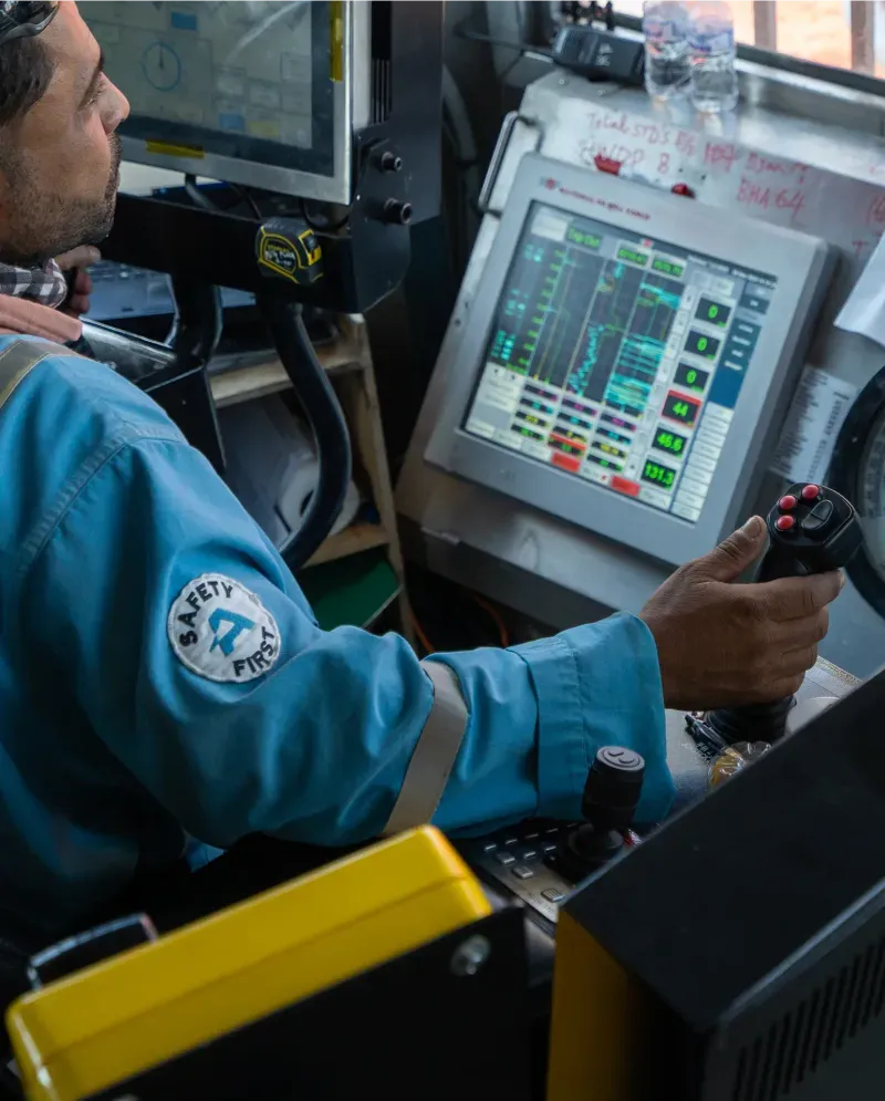 ABRAJ driller operating rig controls from the doghouse chair